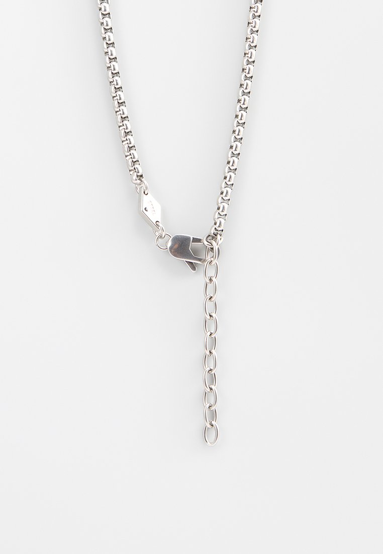 Silberne Metallkettengürtel mit Gliedern, ausgestattet mit einem Verschluss und einer verstellbaren Kettenverlängerung. Glatte Textur und polierte Oberfläche.