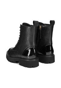 Černé kožené kotníkové boty s prošívaným designem, lesklými akcenty z lakované kůže a silnými gumovými podrážkami; boční zip a přední šněrování.