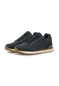 Marineblaue Sportschuhe mit einem glatten Lederobermaterial, perforierten Details, tonalen Schnürsenkeln und einer beigefarbenen Gummisohle. Auf der Seite befindet sich ein Logo.