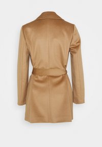 Leikattu, vyöllä varustettu kamelinvärinen villakangastakki, jossa on lovikaulus ja muotoiltu siluetti. Sileä rakenne ja räätälöity takaosa.