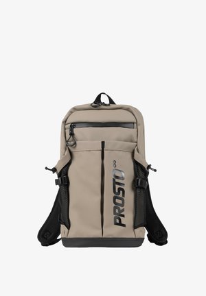 Beżowy prostokątny plecak z czarnymi siateczkowymi bocznymi kieszeniami, przednią kieszenią na zamek, górnym uchwytem, regulowanymi paskami i logo "PROSTO" na przedniej klapie.