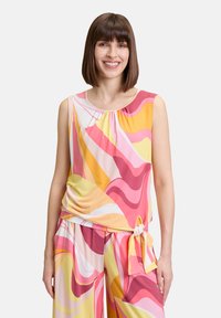 Kolorowa bezrękawnik z zebranym dekoltem, z falistym, abstrakcyjnym wzorem w odcieniach różu, żółci i bieli, wykonana z lekkiego materiału.