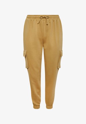 Lichtbruine trainingsbroek met een koord in de taille, ribbels aan de mouwen en twee zijzakken. Gemaakt van zachte, gladde stof.