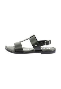 Sandalia de cuero negro con diseño de tira en T, hebilla ajustable en el tobillo y suela plana con textura suave.