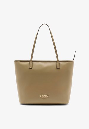 Bézs bőrből készült válltáska két vállpánttal, szegecses díszítéssel és dombornyomott logóval az elején. Simák a felülete, téglalap alakú.