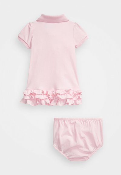 Šviesiai rožinė medvilninė suknelė su trumpomis pūstomis rankovėmis ir apykakle, turinti raukšlėtą apatinę dalį. Į komplektą įeina atitinkamos raukšlėtos trumpikes.