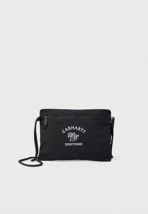 Borsa a tracolla nera Carhartt Wip con tasca frontale con zip e logo bianco "Carhartt Wip Eightynine", con tracolla regolabile.
