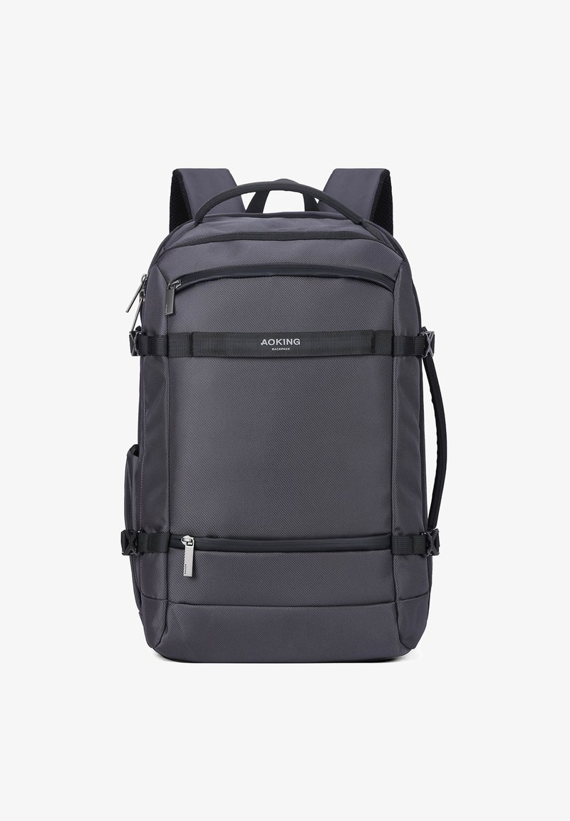 Zaino grigio con superficie tessurizzata, numerosi scomparti con cerniera, spallacci regolabili e una maniglia superiore rinforzata per il trasporto.