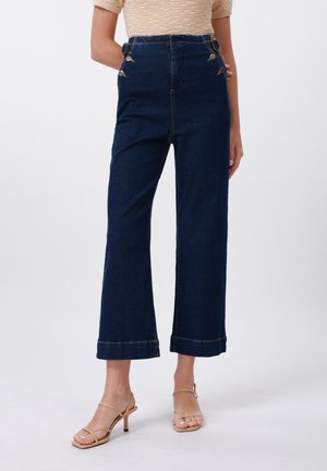 Pantaloni din denim de culoare albastru închis, cu talie înaltă și picioare largi, având butoane decorative pe talie și tiv cusut. Textură netedă.