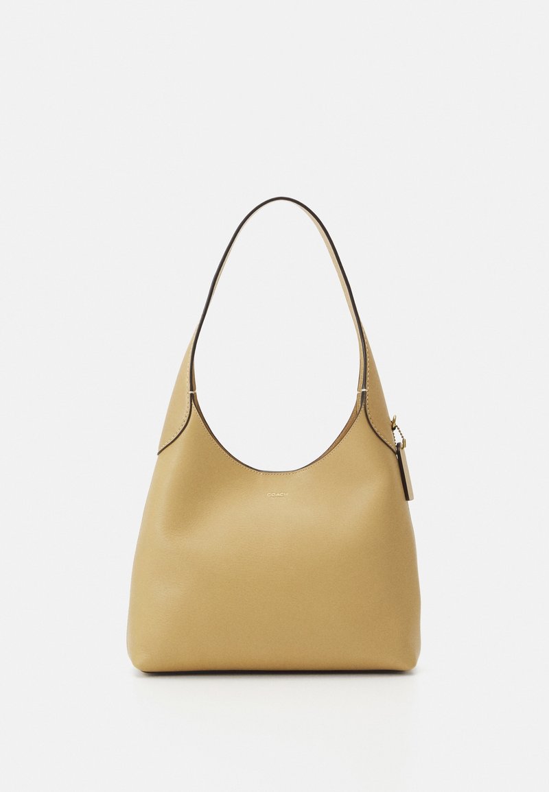 Gestructureerde hobo tas in licht mosterdkleurig leer met een gladde textuur en een gebogen schouderband. Voorzien van een geperst logo en een ritsvak detail.