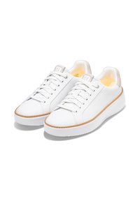 Sneakers bianchi in pelle con punta arrotondata, dotati di una suola testurizzata, lacci piatti e dettagli in colori chiari sul tallone e sulla linguetta.