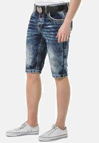 Denim-Shorts in einem hell-zu-dunkelblauen Farbverlauf, mit klassischer Passform, Kontrastnähten, fünf Taschen und einem schwarzen Gürtel mit dekorativer Schnalle.