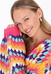 Kolorowy sweter z dzianiny o grubej strukturze w odcieniach różu, turkusu, żółci i fioletu. Długie rękawy z prążkowanymi mankietami.