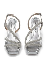 Sandali con tacco argentato, caratterizzati da cinturini incrociati in strass, tacco a blocco e punta squadrata. Soletta morbida beige con dettagli del logo.