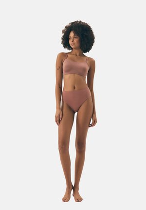 Brązowy dwuczęściowy bikini wykonany z gładkiego materiału. Biustonosz w stylu bralette z cienkimi ramiączkami oraz wysoko zabudowane majtki z minimalnymi szwami i jednolitym kolorem.