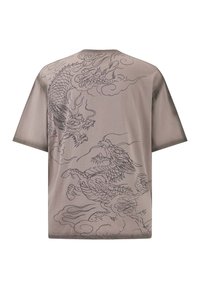 Camiseta de manga corta de gran tamaño en marrón claro con diseños de dragón negro y nubes. Textura suave, escote redondo y corte relajado.