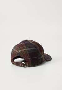 Vue arrière d'une casquette en tissu ajustable avec un motif écossais marron, vert et rouge et une sangle à boucle en métal sur fond blanc.