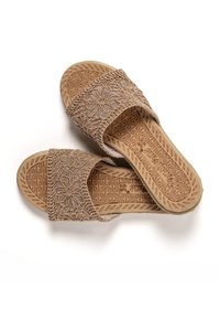 Tan fabric slide sandals with floral lace design, textured sole, and beige rubber outsole. Open toe and wide strap for ease of wear.