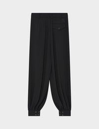 Pantalon noir fuselé avec plis, poignets boutonnés, passants de ceinture et une poche arrière boutonnée avec un petit logo au-dessus.