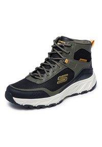 High-Top-Sneaker aus einer Kombination von schwarzem Mesh und olivgrünem synthetischen Material, mit weißer Sohle und gelben Akzenten.