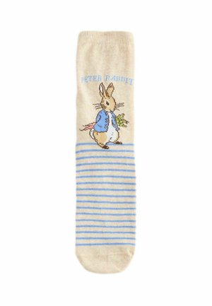 Beige Socke mit hellblauen Streifen und einer Illustration von Peter Hase, der eine blaue Jacke trägt und Gemüse hält, mit dem Text "Peter Hase" darüber.