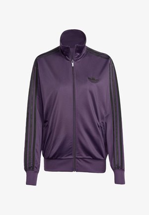 Fialová sportovní bunda vyrobená z hladkého materiálu, s vysokým límcem, černými pruhy podél rukávů a vyšitým logem na hrudi.