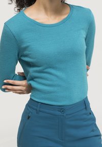 Teal textured long-sleeve top with round neckline paired with matching teal pants featuring a front button closure and side pocket.