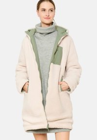 Fleeces mētelis gaiši rozā krāsā ar zaļu kapuci, ar priekšējo rāvējslēdzēju, sānu kabatām un teksturētu virsmu siltumam. Minimalistisks dizains.