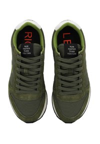 Sneakers sportive verde oliva in materiali scamosciati e in rete, con lacci piatti e suole in gomma. Le solette mostrano il testo "CORRI PIÙ VELOCE DI QUANTO PUOI."