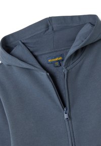 Sudadera con capucha y cremallera en color azul oscuro, fabricada en suave algodón, cuenta con una cremallera de metal y una etiqueta con la palabra "esenciales".