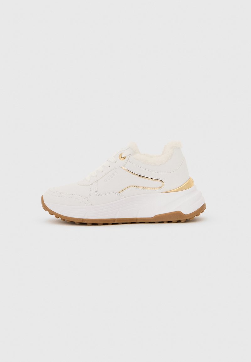 White sneaker with a textured upper, faux fur collar, and gold accent detailing, featuring a chunky rubber sole and lace-up front.