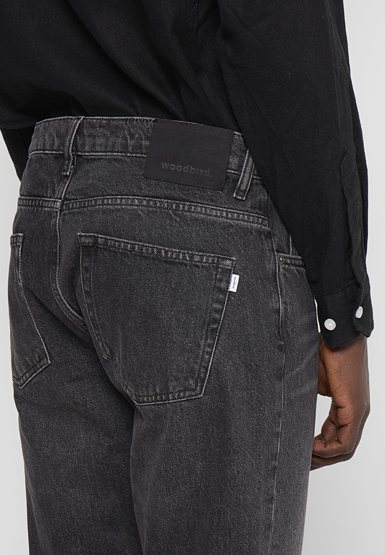 Zwarte denim jeans met een getextureerde afwerking, voorzien van twee achterzakken en een leren label met merknaam op de taille.