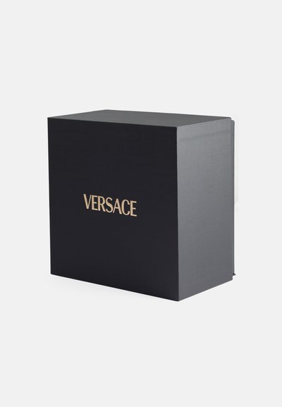 Caja rectangular negra con un acabado texturizado. Presenta el logo dorado "VERSACE" en la parte frontal. Sin hardware ni acentos visibles.
