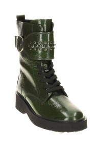 Groene gepatineerde leren enkellaarsjes met vetersluiting, band met zilveren studs en een chunky zool. Textuurafwerking voegt visuele interesse toe.