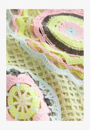 Lähivõte pastellvärvilisest heegeldatud kangast, millel on roosade, kollaste, siniste ja pruunide lõngadega ringikujulised ja silmalõikuvad mustrid.