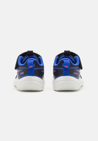 Baskets de sport bleues et noires avec une tige en mesh, semelle blanche, col rembourré et sangle ajustable pour un ajustement sécuritaire. Vue arrière.