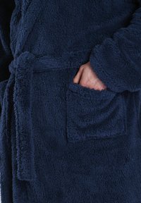 Marineblaue Fleece-Robe mit einer strukturierten, flauschigen Oberfläche, ausgestattet mit einem Bindegürtel und einer Vordertasche auf der rechten Seite.