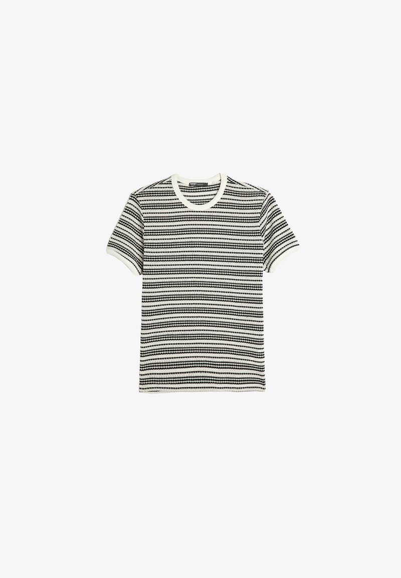 Camiseta de rayas en blanco y negro con mangas cortas, escote redondo y un diseño de punto texturizado. Acentuada con bordes ribeteados en blanco.