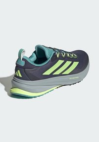 Scarpa da atletica da uomo con parte superiore in rete blu navy, dettagli verde lime, tallone rinforzato e intersuola grigia imbottita per comfort e supporto.