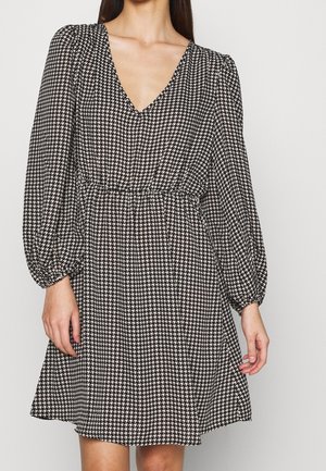 Schwarz-weißer, gemusterter Kleid mit V-Ausschnitt, langen Puffärmeln und elastischem Bund, mit einem ausgestellten Rock und Hahnentrittmuster.