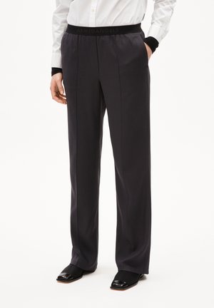 Donkergrijze broek van een gladde stof, met een zwarte elastische tailleband met het logo "ARMEDANGELS", een getailleerde pasvorm en een rechte pijp.