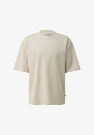 Beżowa koszulka z krótkim rękawem, z okrągłym dekoltem i luźnym krojem, jednolity wzór, prezentowana na białym tle.