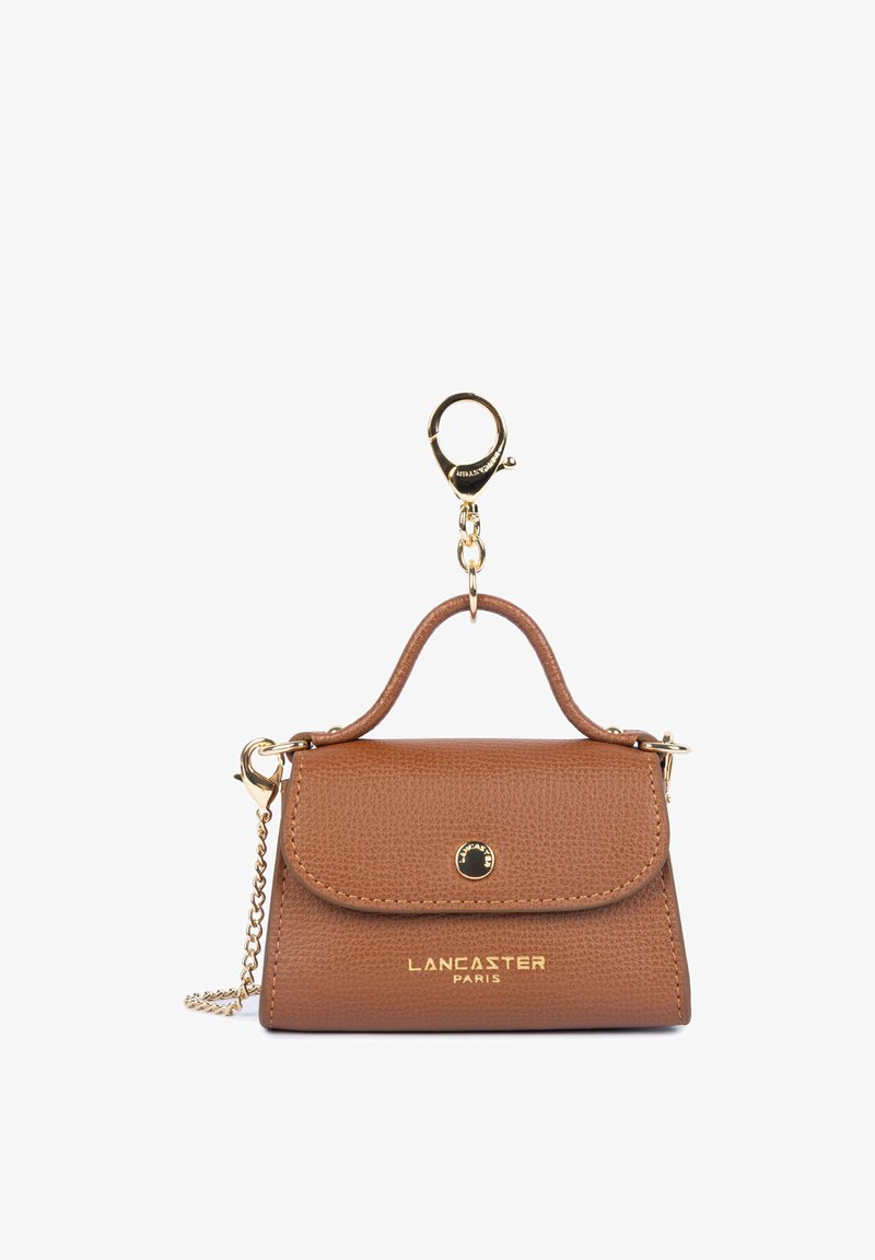Petit porte-clés de sac à main Lancaster Paris en cuir marron avec fermoir et chaîne dorés sur fond blanc.