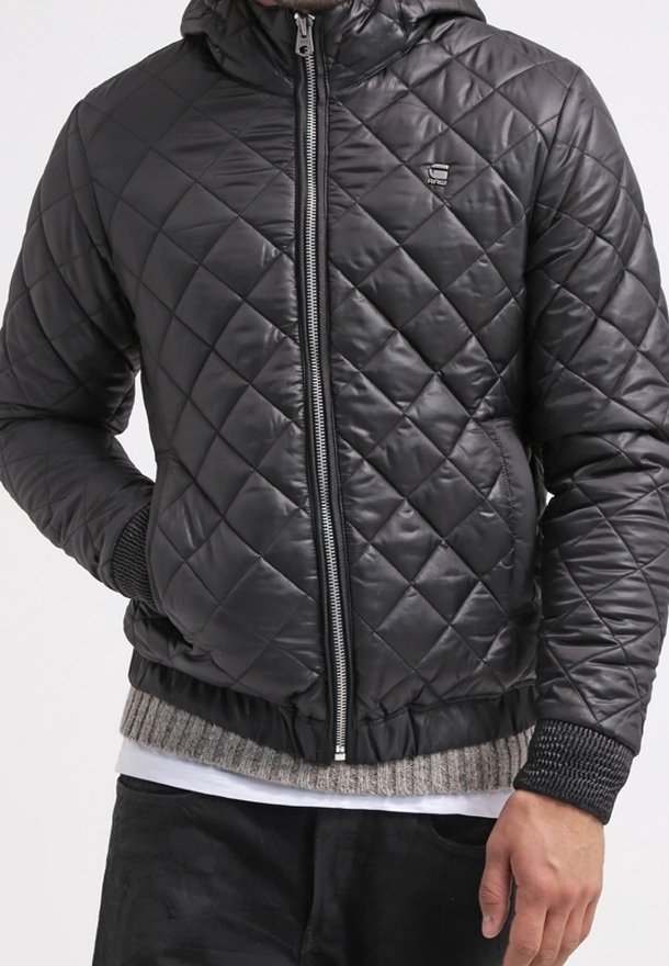 Czarna pikowana kurtka puchowa z kapturem, z zapięciem na zamek z przodu, ściągaczami na rękawach i teksturowanym dołem. Srebrny detal z logo na piersi.