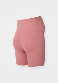 Pantaloni sportivi Nike in morbido tessuto rosa, con vita alta, tasche laterali e cuciture lisce per una silhouette aderente.