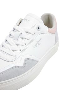 Sneaker bianco con accenti in suede grigio, dotato di una tomaia in pelle liscia, design con lacci e un sottile dettaglio del logo sul lato.