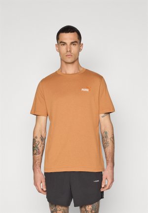 Korte mouwen, ronde hals t-shirt in brandrood katoen, voorzien van een wit Puma-logo op de borst. Gedragen met zwarte shorts.