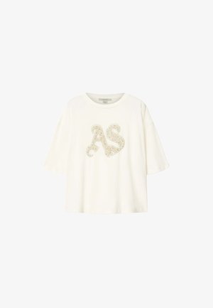 T-shirt blanc à manches courtes avec encolure arrondie, présentant des lettres décoratives "AS" beiges ornées de motifs floraux sur le devant.