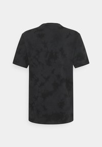 Mustat sidontakuviolla varustettu lyhythihainen t-paita, jossa on klassinen pyöreä kaula-aukko. Pehmeä kangas, jossa on vaihtelevia mustan sävyjä, ja siinä on teksturoitu, abstrakti kuvio.