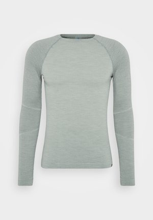 Light green long-sleeve thermal top with ribbed texture, raglan sleeves, and seamless accents on the shoulders and arms.